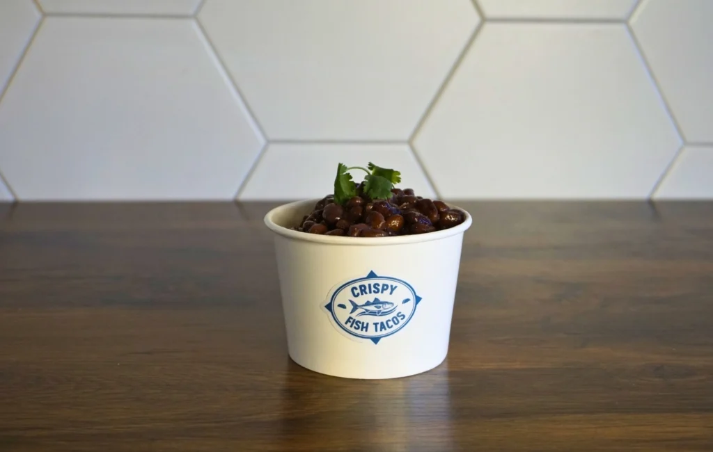 A cup filled with food placed on a wooden table, showcasing a colorful and appetizing dish.